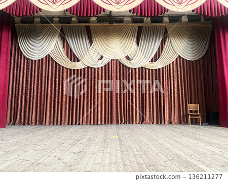 Retro-style school assembly hall featuring elegant draped curtains and wooden stage, creating a nostalgic atmosphere for educational events and performances with copy space 136211277