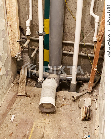 Old toilet in a dilapidated house with exposed plumbing and debris, showcasing the need for extensive renovations and restoration in a neglected bathroom environment Old toilet in a dilapidated house with exposed plumbing and debris, showcasing the need for extensive renovations and restoration in a neglected bathroom environment 136211284