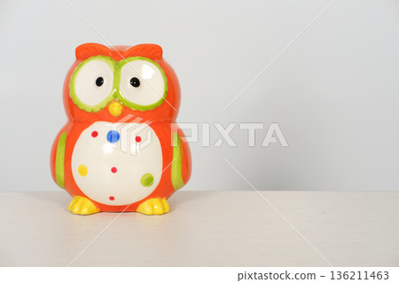 Colorful ceramic owl toy with vibrant patterns on a white background, featuring playful design elements and ample copy space for creative use 136211463