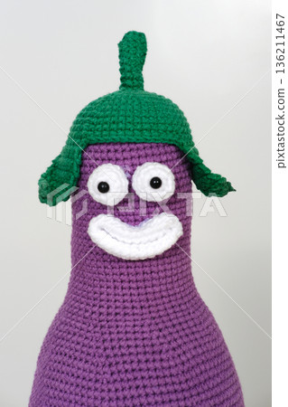 Colorful purple character with a green hat and smiling face, crafted from yarn, showcasing a playful design and whimsical expression, ideal for children's themes and creative projects 136211467