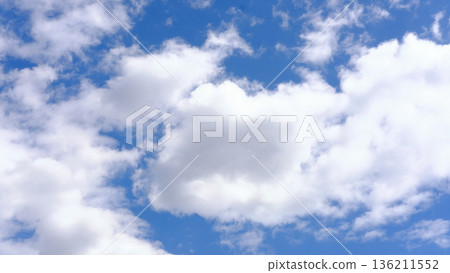 Bright blue sky filled with fluffy white clouds, creating a serene atmosphere, ideal for backgrounds or nature-themed projects, showcasing the beauty of the sky 136211552