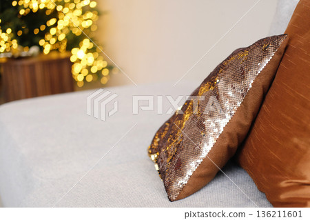 Decorative cushions on a cozy sofa, featuring a shimmering sequin pillow and a soft brown fabric pillow, creating a warm and inviting atmosphere in a stylish living room Decorative cushions on a cozy sofa, featuring a shimmering sequin pillow and a soft brown fabric pillow, creating a warm and inviting atmosphere in a stylish living room 136211601