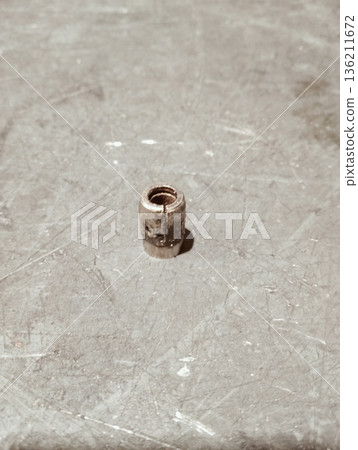 Broken metal compression ferrule with crack on industrial background 136211672