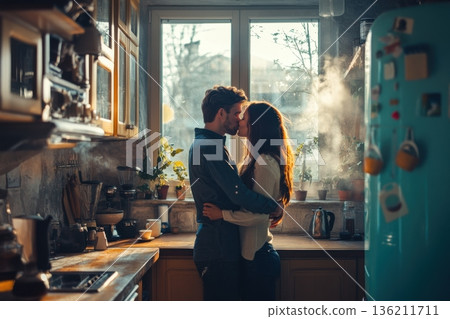 Romantic couple embracing in a cozy kitchen filled with sunlight in the morning while steam rises from the cooking area 136211711