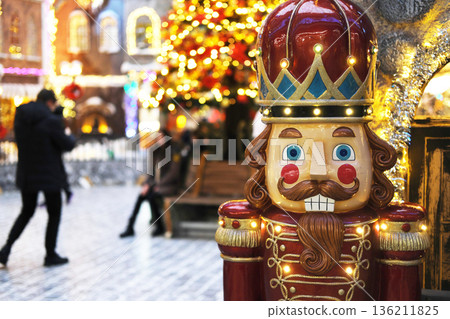 Colorful nutcracker decoration stands in a festive shopping mall adorned with bright lights and Christmas trees, creating a joyful holiday atmosphere for shoppers and visitors Colorful nutcracker decoration stands in a festive shopping mall adorned with bright lights and Christmas trees, creating a joyful holiday atmosphere for shoppers and visitors 136211825