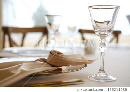 Elegant dining table setting featuring crystal glassware, fine china, and soft fabric napkins, creating a sophisticated atmosphere for special occasions and gatherings Elegant dining table setting featuring crystal glassware, fine china, and soft fabric napkins, creating a sophisticated atmosphere for special occasions and gatherings 136211986