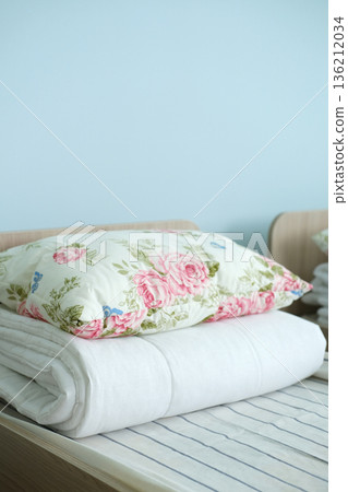 Cozy children's bed with floral pillow and soft blanket arranged neatly, creating a warm and inviting sleep environment for preschool and kindergarten children Cozy children's bed with floral pillow and soft blanket arranged neatly, creating a warm and inviting sleep environment for preschool and kindergarten children 136212034