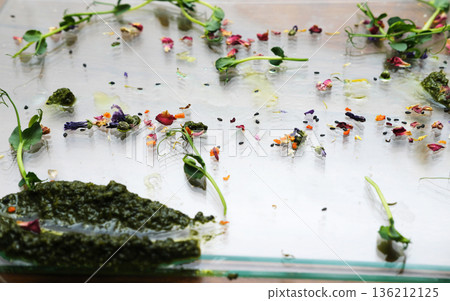 Leftover food remnants on a glass surface, showcasing vibrant colors and textures, highlighting the concept of food waste disposal and the impact of culinary excess Leftover food remnants on a glass surface, showcasing vibrant colors and textures, highlighting the concept of food waste disposal and the impact of culinary excess 136212125
