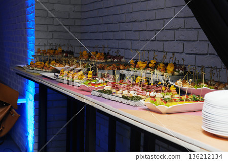Colorful array of appetizers displayed on a table in a vibrant event room, showcasing culinary creativity and artistic presentation with a lively atmosphere Colorful array of appetizers displayed on a table in a vibrant event room, showcasing culinary creativity and artistic presentation with a lively atmosphere 136212134