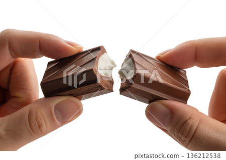 Close-up of hands breaking apart a creamy, filled chocolate bar, revealing the delicious soft center. Ideal for indulgence and food cravings Close-up of hands breaking apart a creamy, filled chocolate bar, revealing the delicious soft center. Ideal for indulgence and food cravings 136212538