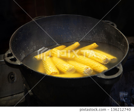 Yellow corn is cooked in a large cauldron 136212740
