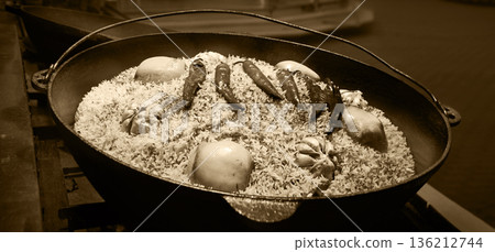 Aromatic pilaf is fried in a cauldron Aromatic pilaf is fried in a cauldron 136212744