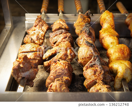 A ruddy kebab is being grilled on a barbecue A ruddy kebab is being grilled on a barbecue 136212748