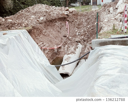 Concrete drainage pipe in construction site excavation with water 136212788