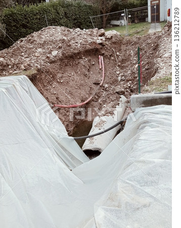 Concrete drainage pipe in construction site excavation with water Concrete drainage pipe in construction site excavation with water 136212789