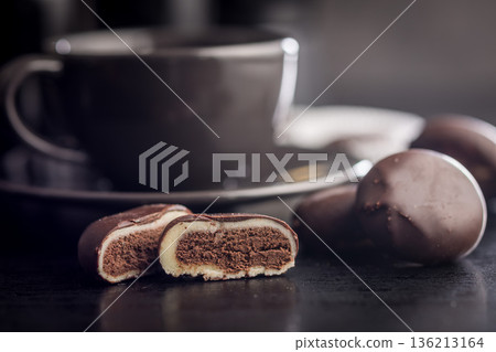 Dark chocolate truffles in the shape of coffee beans on black table. Dark chocolate truffles in the shape of coffee beans on black table. 136213164