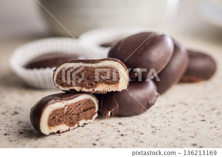 Dark chocolate truffles in the shape of coffee beans on kitchen table. 136213169