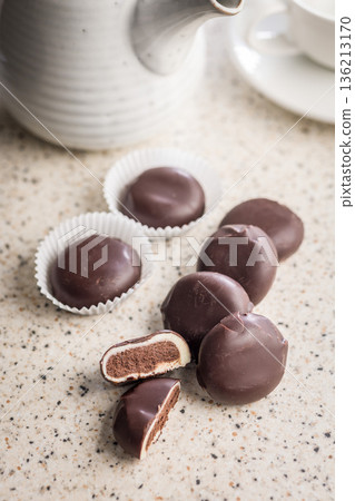 Dark chocolate truffles in the shape of coffee beans on kitchen table. 136213170