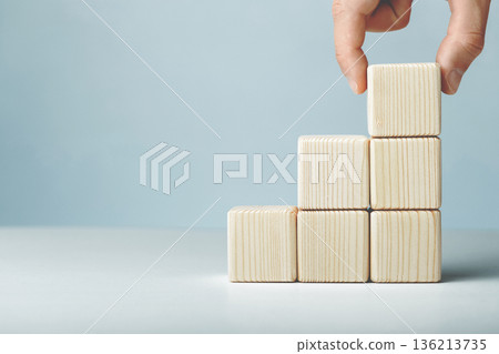 Hand putting and stacking blank wooden cubes on table with copy space for input wording or infographic icon Hand putting and stacking blank wooden cubes on table with copy space for input wording or infographic icon 136213735
