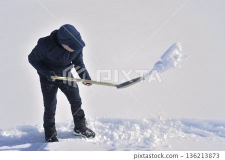 An elderly man living in a rural area with heavy snowfall is clearing snow An elderly man living in a rural area with heavy snowfall is clearing snow 136213873