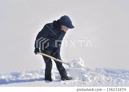 An elderly man living in a rural area with heavy snowfall is clearing snow An elderly man living in a rural area with heavy snowfall is clearing snow 136213874