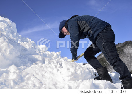 An elderly man living in a rural area with heavy snowfall is clearing snow An elderly man living in a rural area with heavy snowfall is clearing snow 136213881