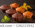 Delicious assortment of muffins garnished with fresh mint leaves on dark background 136213932