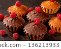Delicious muffins and ripe raspberries displayed on a stylish black kitchen table 136213933