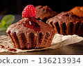 Yummy muffins and fresh raspberries delightfully arranged on a black kitchen table 136213934