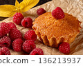 Gourmet lemon muffins with ripe raspberries displayed on a kitchen table setting 136213937