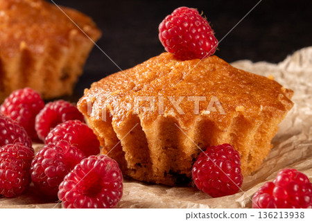Lemon muffins surrounded by juicy raspberries on a cozy kitchen table scene Lemon muffins surrounded by juicy raspberries on a cozy kitchen table scene 136213938