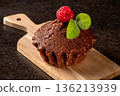 Close-up of a decorated raspberry muffin on a wooden cutting board 136213939