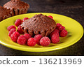 Delicious muffin on a bright green plate surrounded by fresh raspberries 136213969