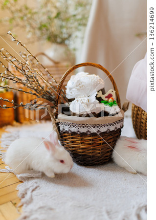 Easter basket with kulich cakes and white bunnies on cozy spring background Easter basket with kulich cakes and white bunnies on cozy spring background 136214699