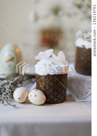 Easter cake with white icing, butterfly topper and eggs in soft spring light 136214701