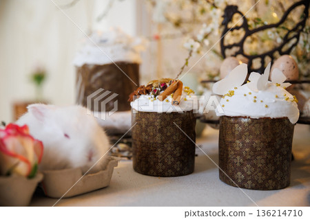 Easter cakes with icing, spices and white bunny, cozy spring still life Easter cakes with icing, spices and white bunny, cozy spring still life 136214710