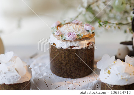 Easter cakes and eggs on lace table with spring blossom branches, soft daylight Easter cakes and eggs on lace table with spring blossom branches, soft daylight 136214713