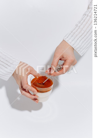 Hands tasting panna cotta with passion fruit topping on white background 136214721