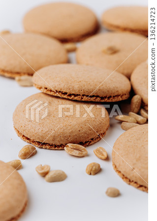Peanut macarons flat lay on white background, minimal dessert texture Peanut macarons flat lay on white background, minimal dessert texture 136214723