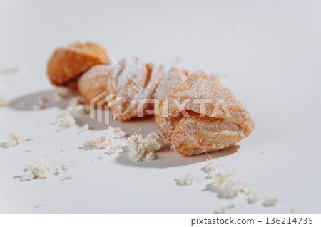 Powdered sugar pastries close-up on white background, soft shadows 136214735