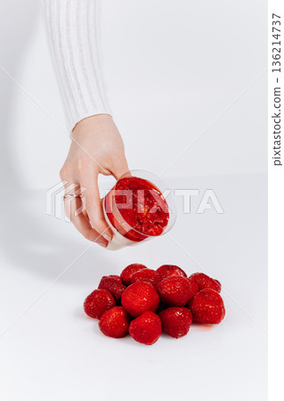 Hand holding strawberry panna cotta dessert cup with fresh berries on white background Hand holding strawberry panna cotta dessert cup with fresh berries on white background 136214737