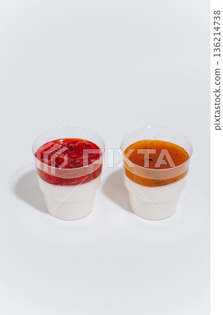 Two panna cotta cups with berry and passion fruit topping on white background Two panna cotta cups with berry and passion fruit topping on white background 136214738