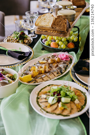Catering banquet table with elegant place settings, appetizers and fruit Catering banquet table with elegant place settings, appetizers and fruit 136214740