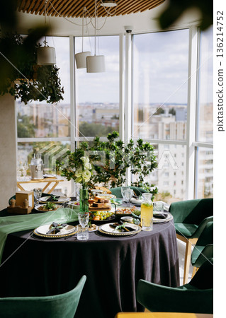 Sunlit rooftop brunch table setup with city view, greenery and lemonade Sunlit rooftop brunch table setup with city view, greenery and lemonade 136214752