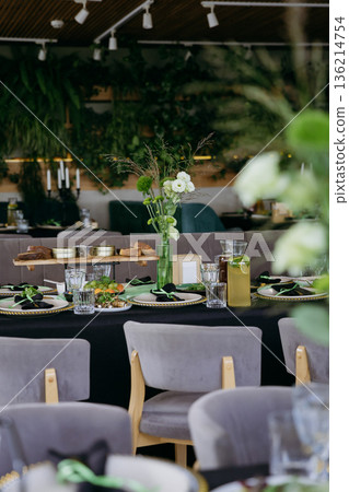Elegant restaurant table setting with greenery centerpiece and lemonade Elegant restaurant table setting with greenery centerpiece and lemonade 136214754