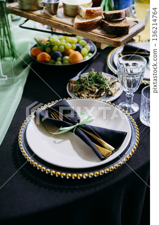 Elegant green and black restaurant tablescape with candelabra and gold accents Elegant green and black restaurant tablescape with candelabra and gold accents 136214764