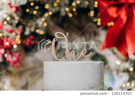One cake topper on white birthday cake with holiday bokeh lights, festive background One cake topper on white birthday cake with holiday bokeh lights, festive background 136214767