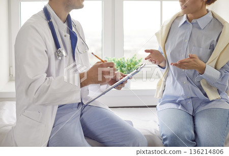 Young woman patient is discussing her treatment with her physician at the hospital Young woman patient is discussing her treatment with her physician at the hospital 136214806