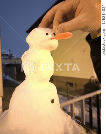 The process of creating a tiny snowman in the evening The process of creating a tiny snowman in the evening 136214824
