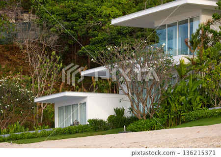 Thailand's coast on a sunny day, villas and hotels among palm trees on a hill, people on a jet ski, a yacht off the coast Thailand's coast on a sunny day, villas and hotels among palm trees on a hill, people on a jet ski, a yacht off the coast 136215371